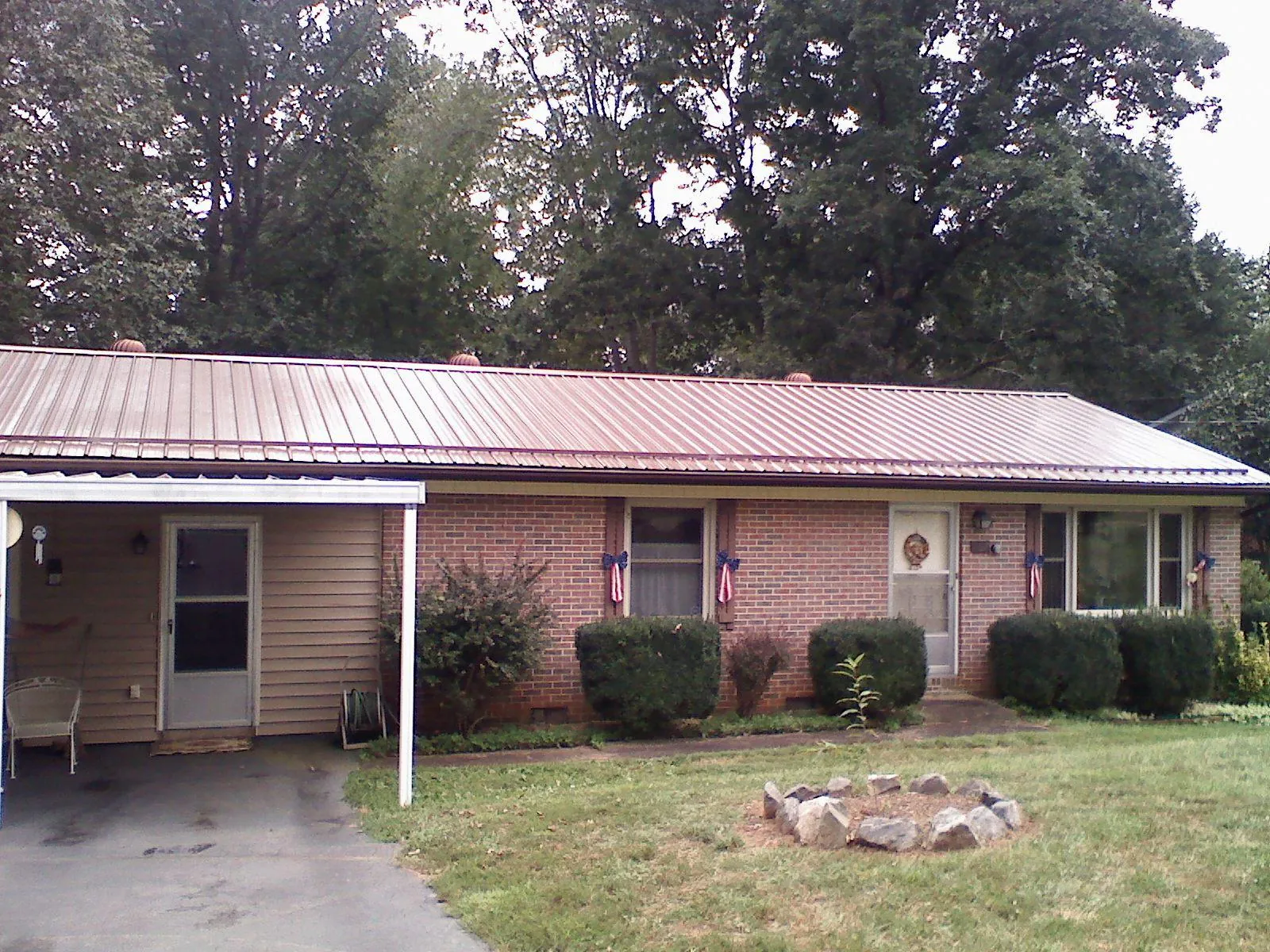 Bronze metal roof and carport on a brick ranch home — Roof Repair work by our crew in Perryman