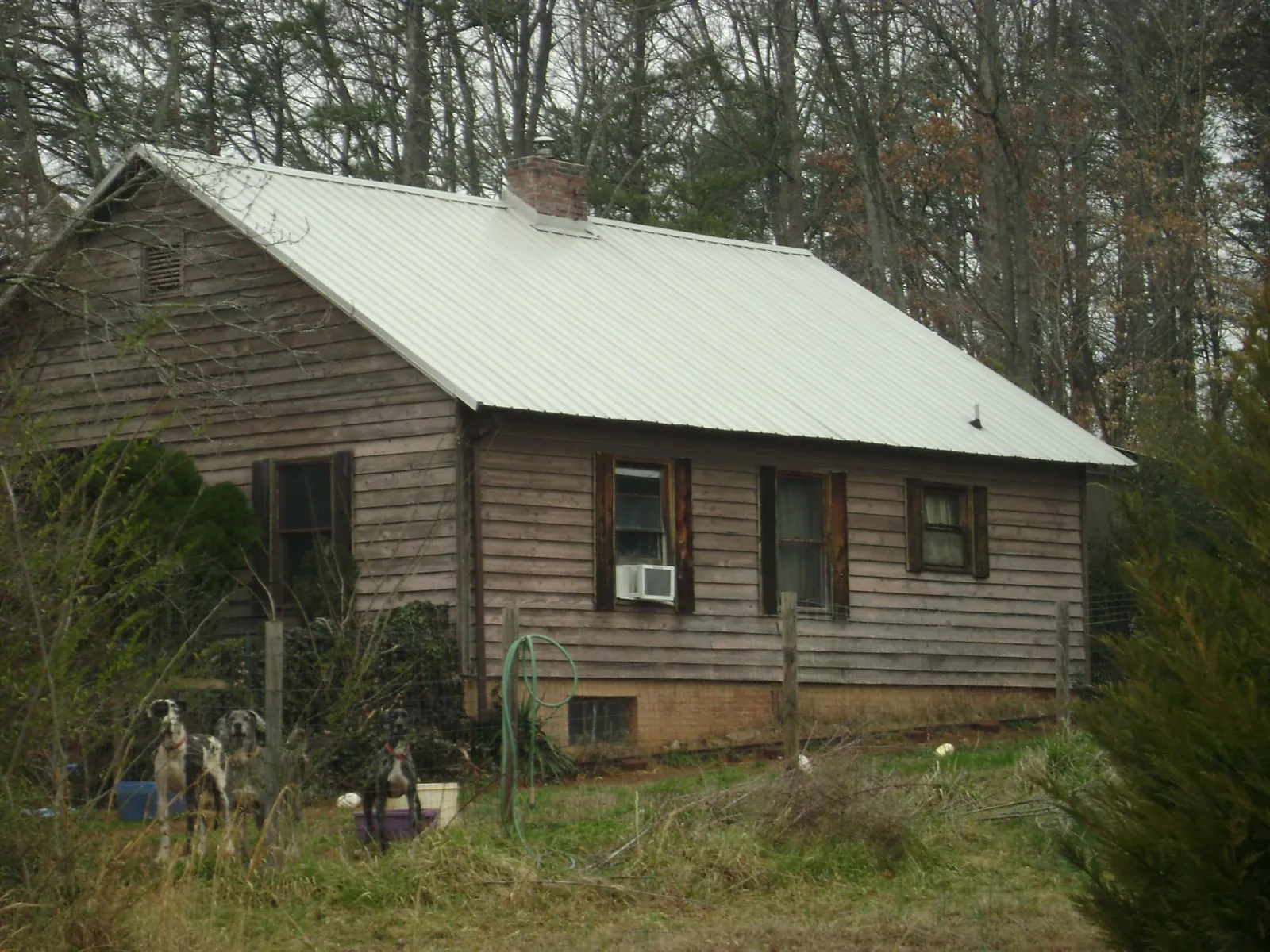 White metal roof on an old wood sided farmhouse, from a Metal Roof Installation job in Perryman